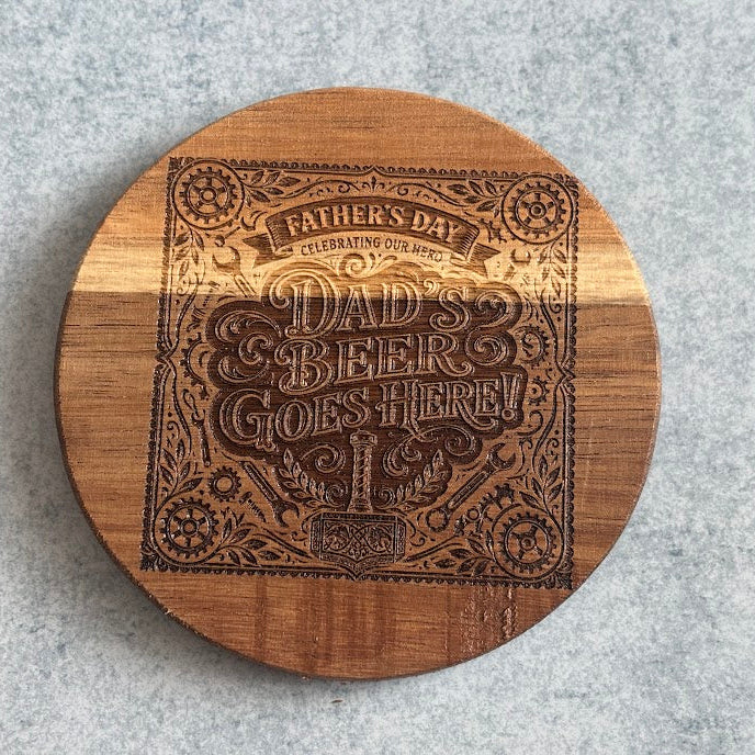 Wooden coaster with engraved design on a gray surface