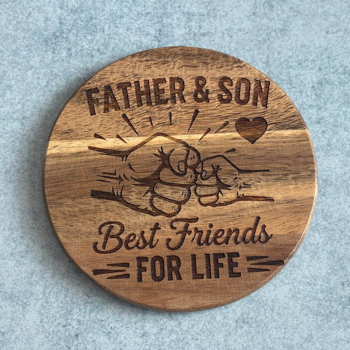Wooden coaster with engraved design and text 'Best Friends For Life Father & Son' on a gray background
