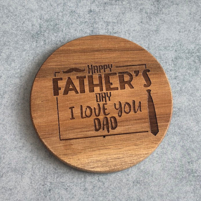 Wooden coaster with engraved text on a gray surface